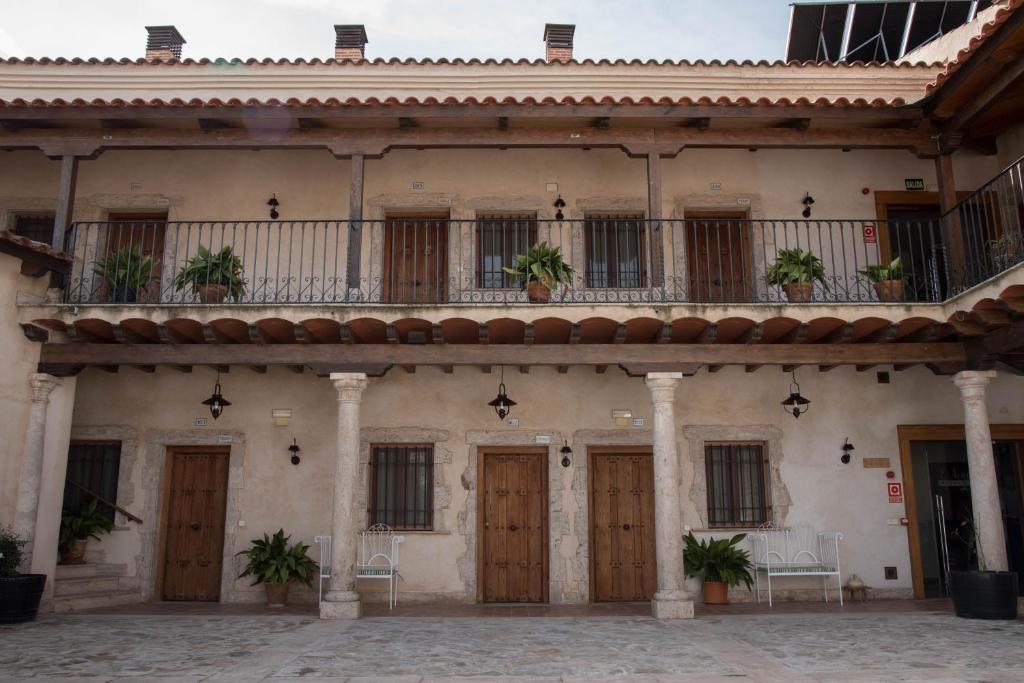 een oud gebouw met houten deuren en een balkon bij Hotel Rural El Lagar in La Solana