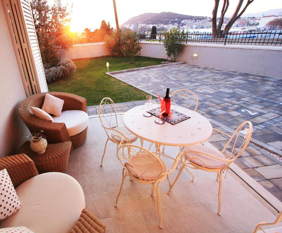 a patio with a table and chairs on a patio at Sunset Beach Apartments in Split