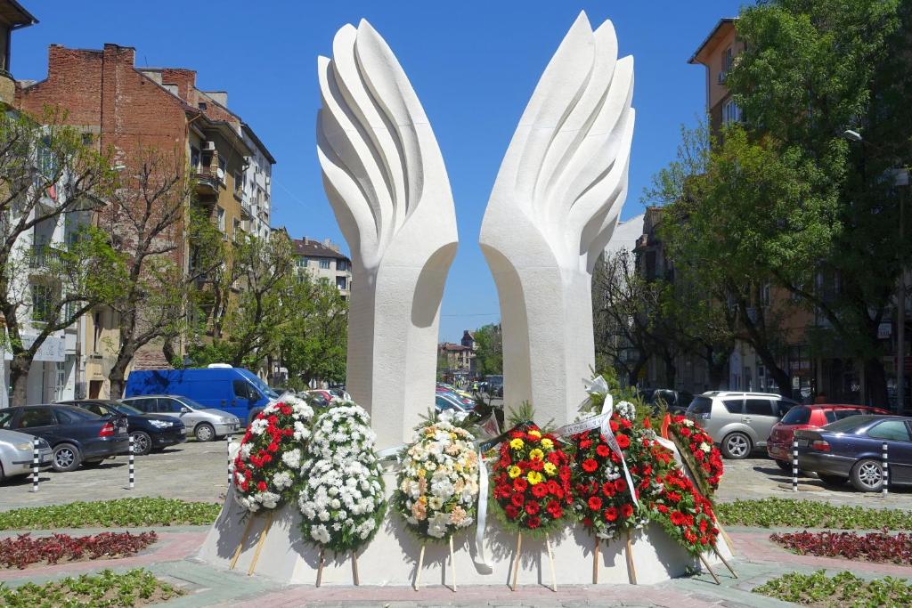a monument with flowers and wreaths on a street at Sunshine Sofia in Sofia