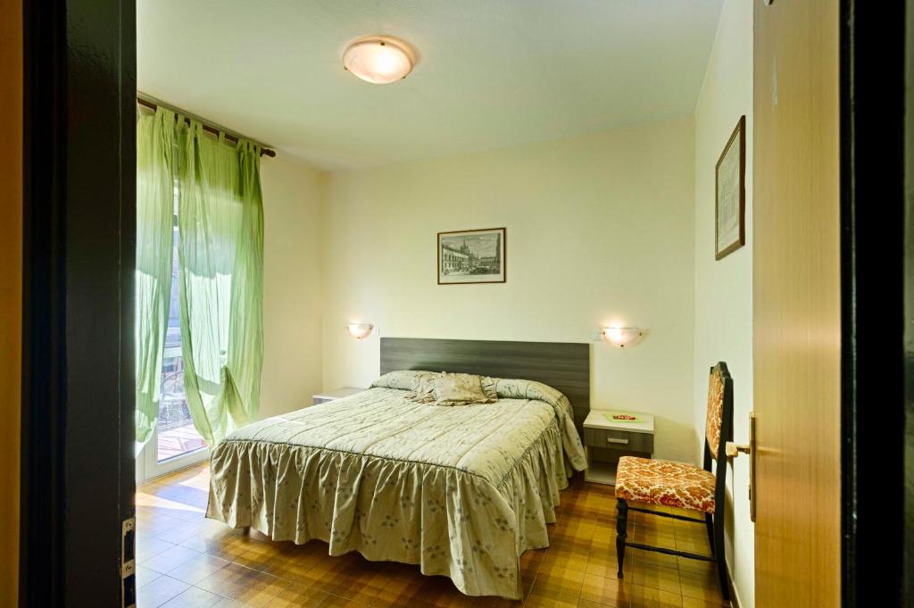 a bedroom with a bed and a lamp on the wall at Albergo Mancuso del Voison in Aosta