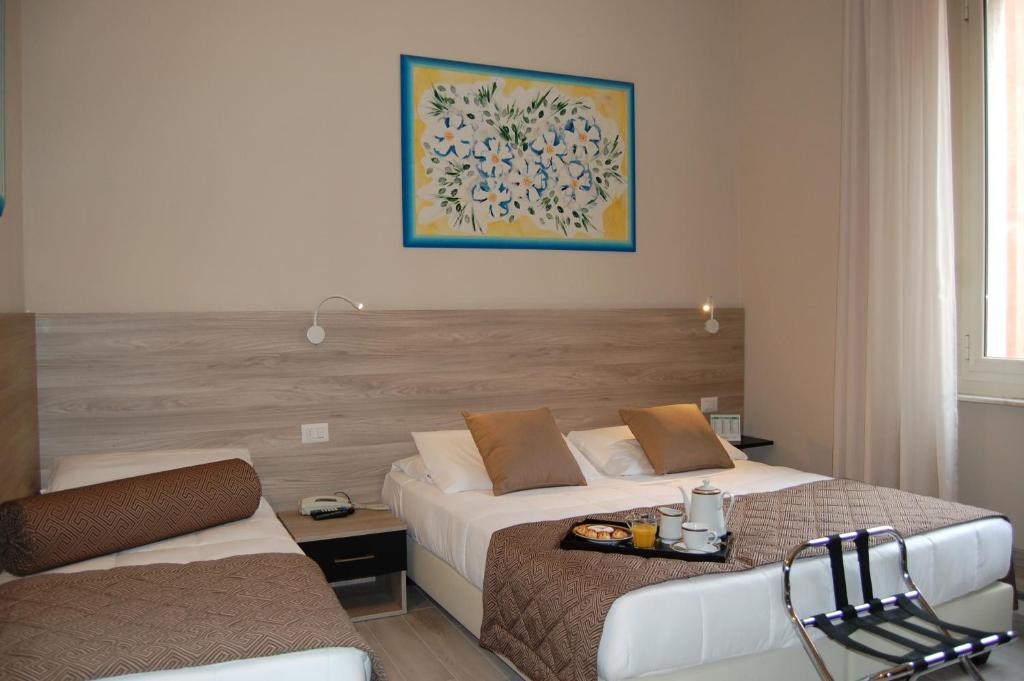 um quarto de hotel com duas camas e uma cadeira em Hotel Citta' em Livorno