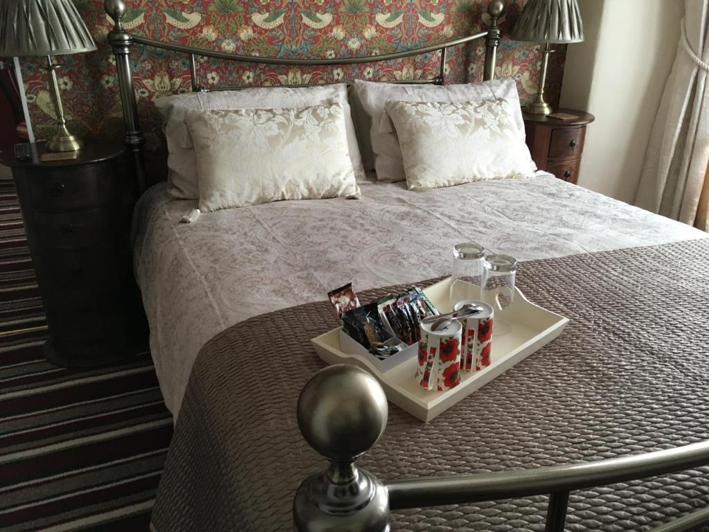 ein Bett mit einem Tablett mit Getränken darauf in der Unterkunft Morlea in Llandudno