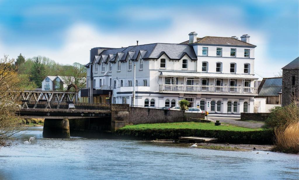 un gran edificio blanco junto a un río con un puente en West Cork Hotel, en Skibbereen