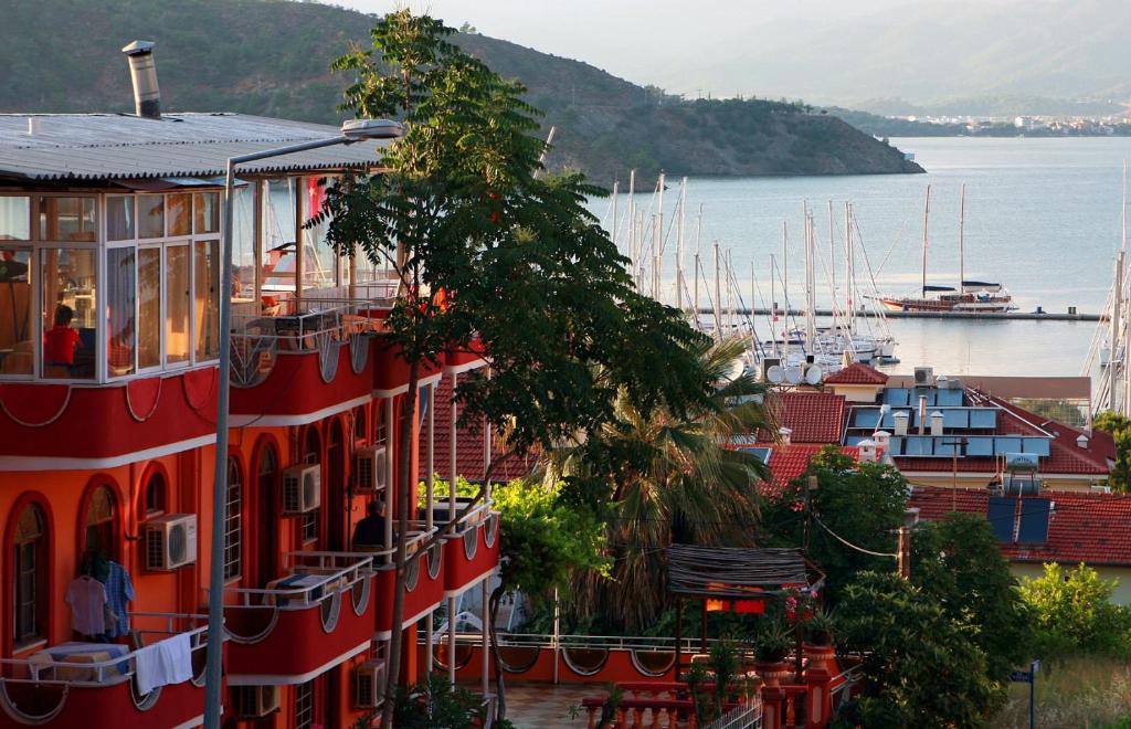a red building next to a harbor with boats at Ideal Pension in Fethiye