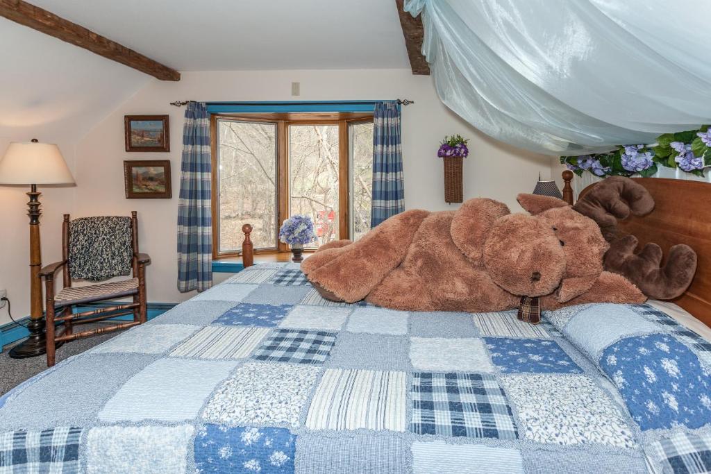 a large teddy bear laying on a bed at Inn at Buck Hollow Farm in Fairfax
