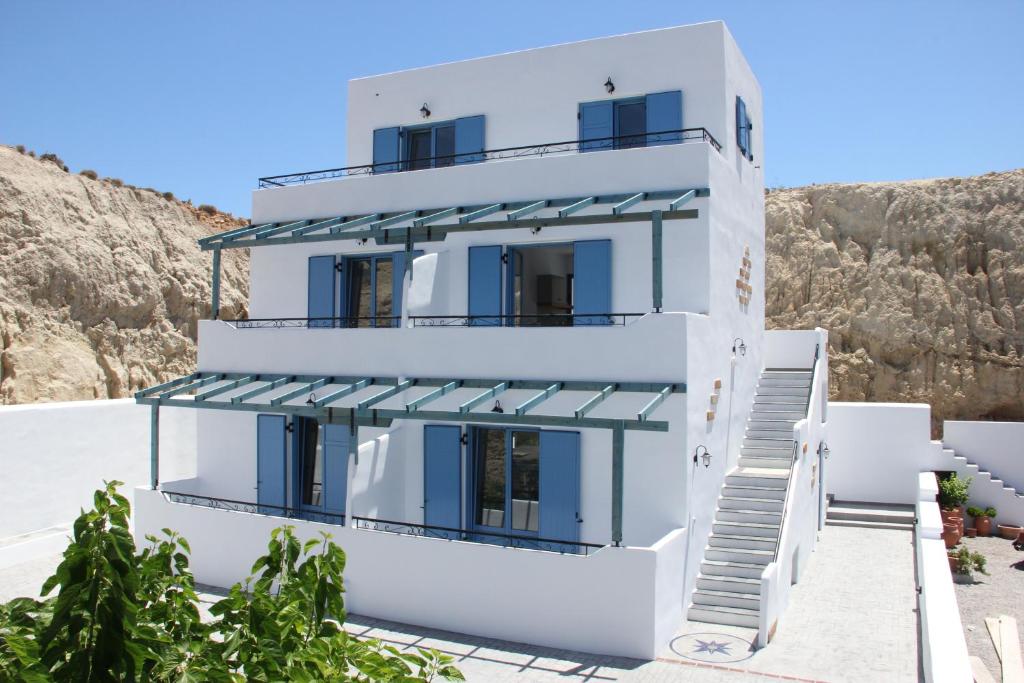 una casa bianca con porte e finestre blu di Pontoria Stegna Studios a Archangelos