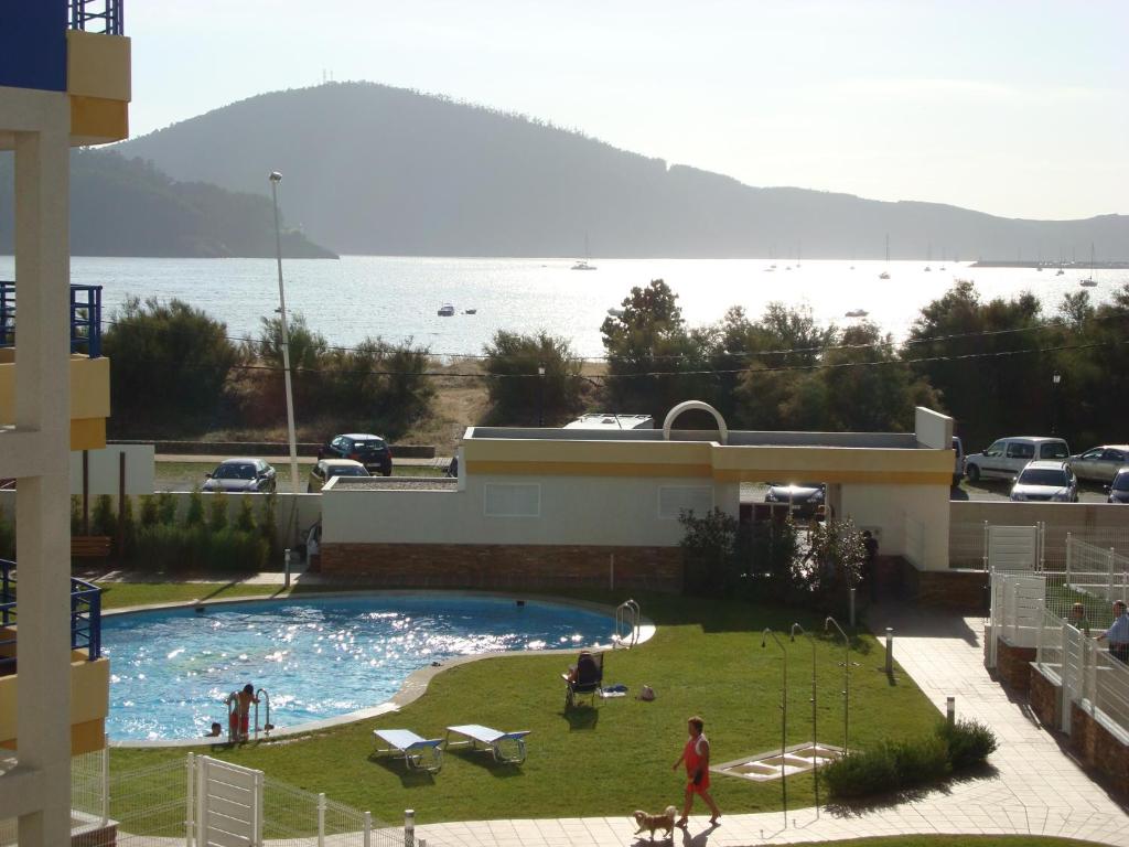 a swimming pool with a view of a body of water at Apartamento Piscina Playa Cedeira in Cedeira