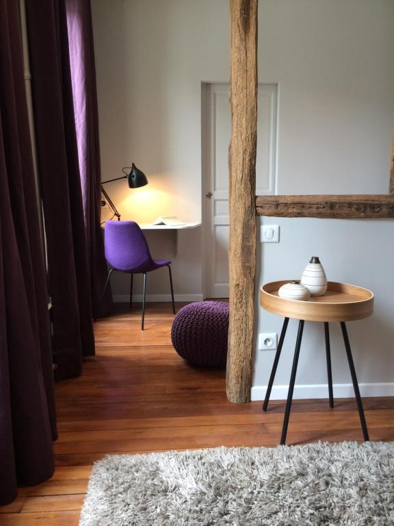 a living room with a table and a purple chair at Wisteria in Fontainebleau