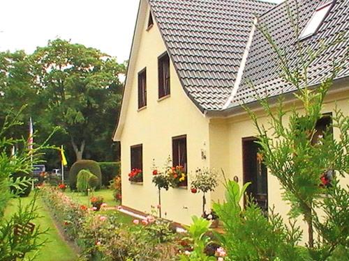 a white house with a garden in front of it at Ferienwohnung Greschke in Prerow