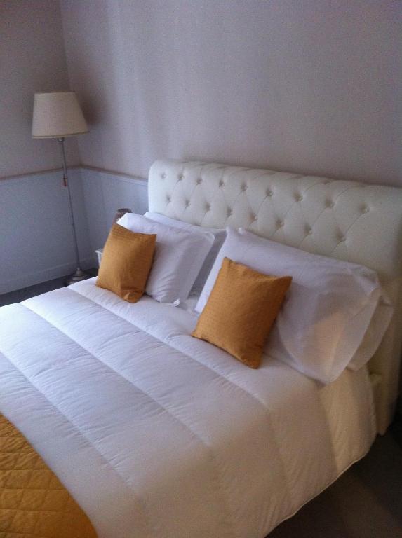 1 cama blanca grande con 2 almohadas en B&B Le Grazie, en Bérgamo