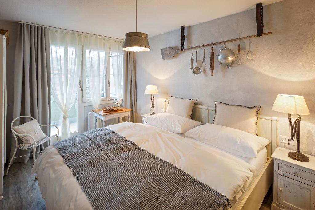 a bedroom with a large white bed and a window at Hotel & Restaurant zum Beck in Stansstad