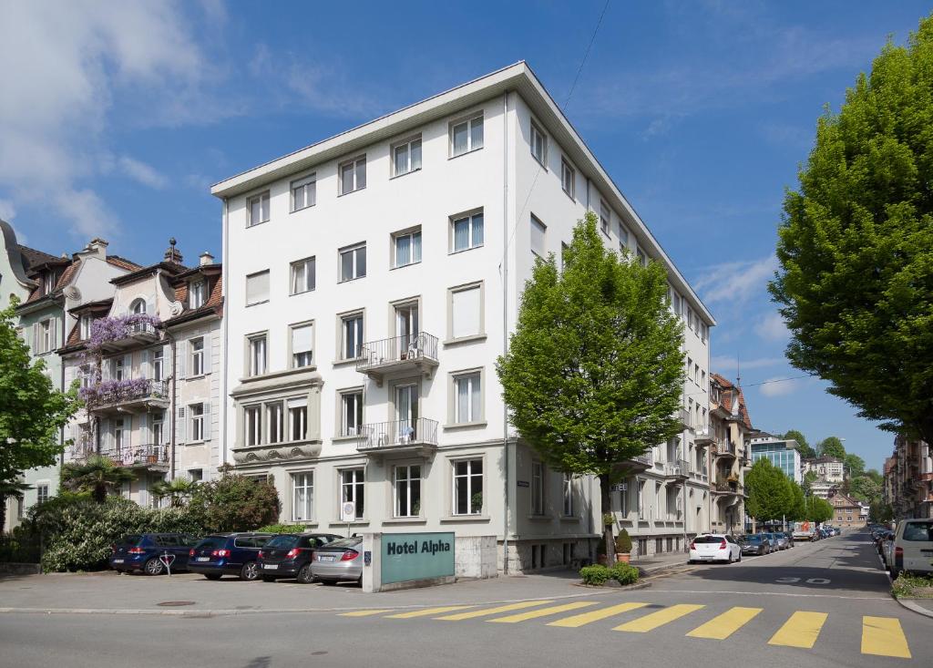 um edifício branco ao lado de uma rua em Hotel Alpha em Lucerna