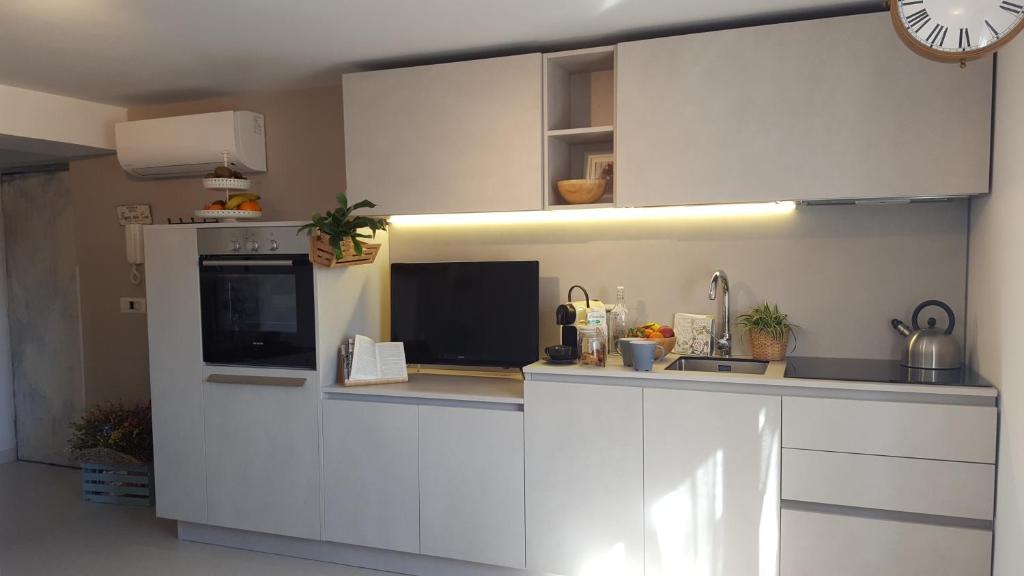 a kitchen with white cabinets and a counter with a microwave at Fly Windows Apartment in Ciampino