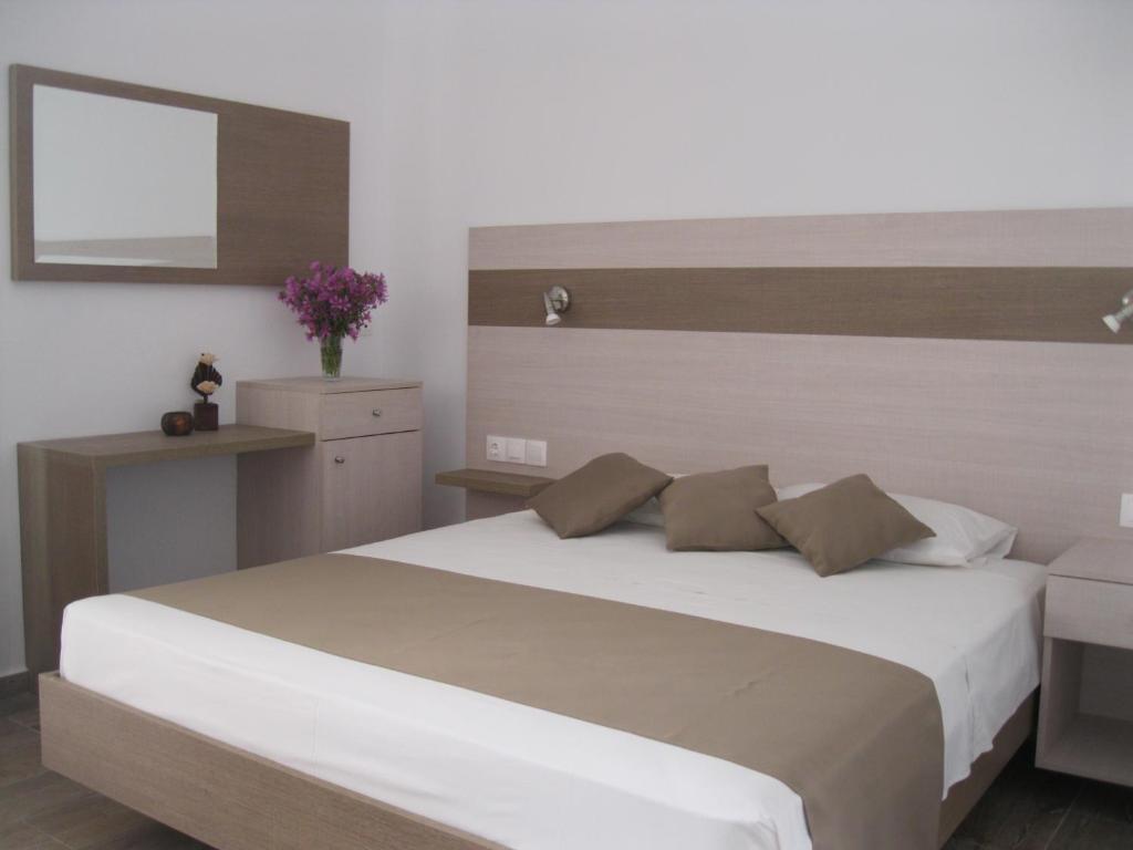 1 dormitorio con 1 cama blanca grande y espejo en Seaside Studios Kirania en Kiotari