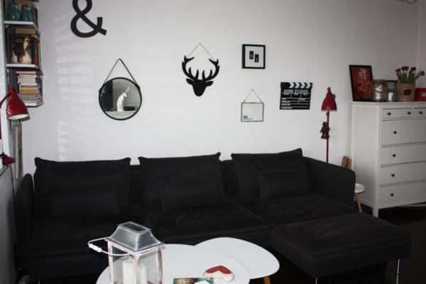 a living room with a black couch and a table at Apartament skandynawski in Gdańsk