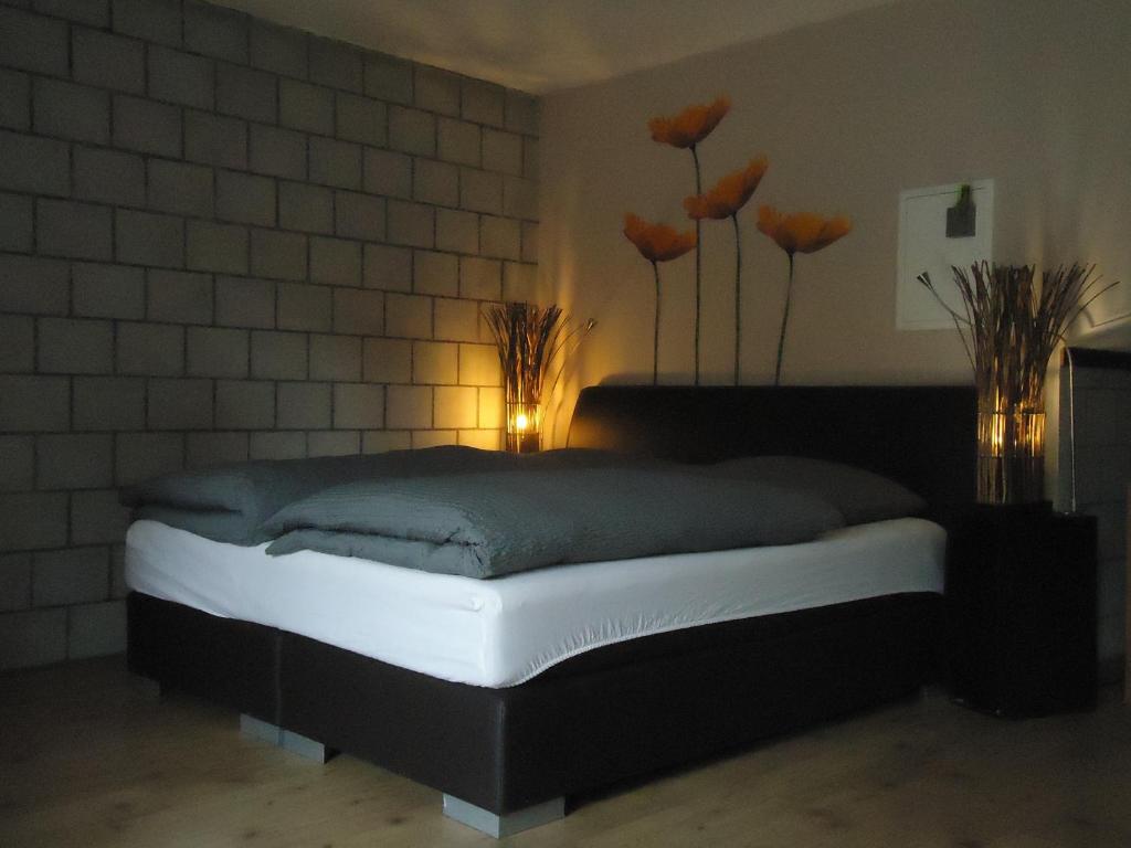 a bedroom with a bed with flowers on the wall at Studios Faoug in Faoug