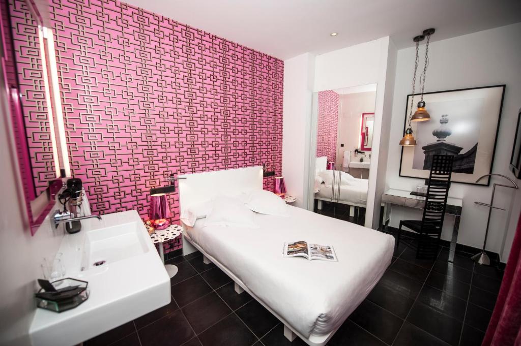 
a hotel room with a white bed and white walls at Posada del León de Oro Boutique Hotel in Madrid
