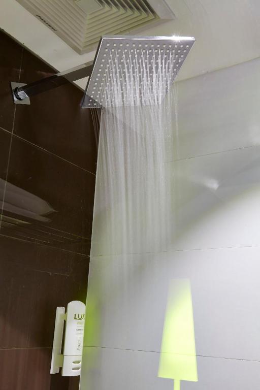 a shower curtain in a bathroom with a phone at IU Hotel Hezhou Bus Terminal in Hezhou