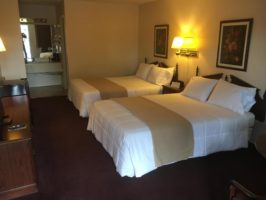 a hotel room with two beds and a kitchen at Alpine Lodge in Eureka Springs