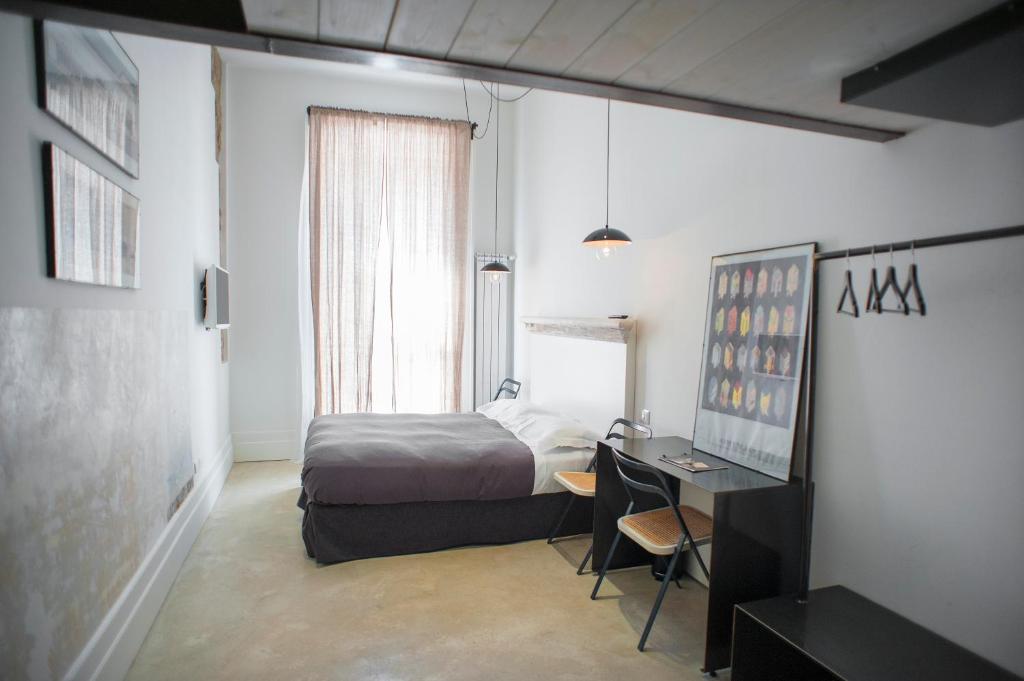 ナポリにあるBelledonne Suite & Galleryのベッドルーム1室(ベッド1台、デスク、コンピュータ付)