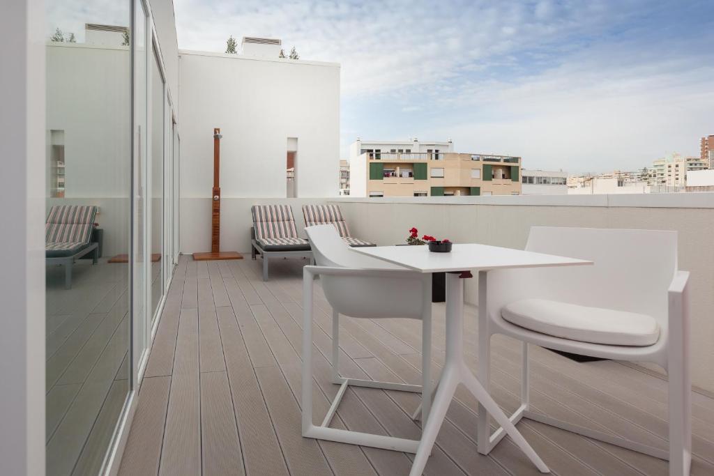 a white table and chairs on a balcony at Faro Boutique Hotel in Faro