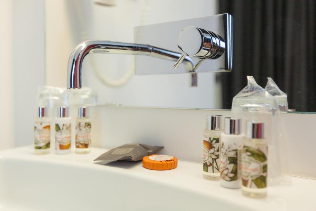 a bathroom counter with a mirror and a sink at Faro Boutique Hotel in Faro