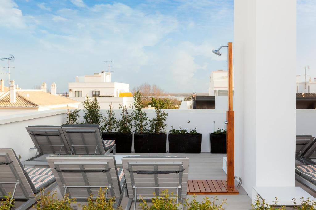 a patio with chairs and a table on a balcony at Faro Boutique Hotel in Faro