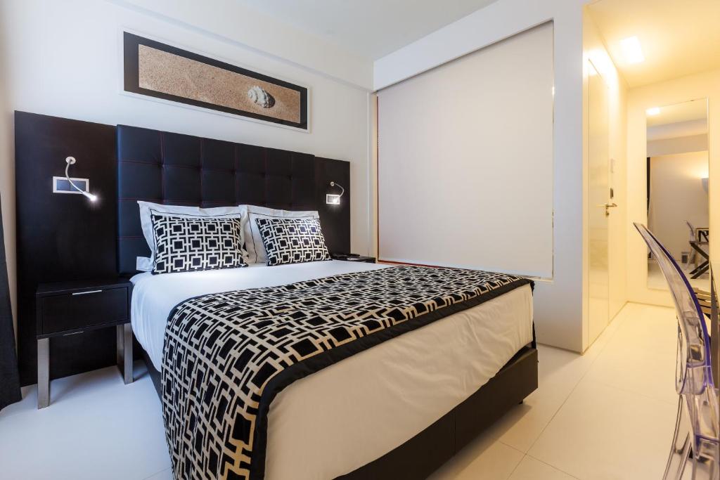 a bedroom with a large bed with a black headboard at Faro Boutique Hotel in Faro