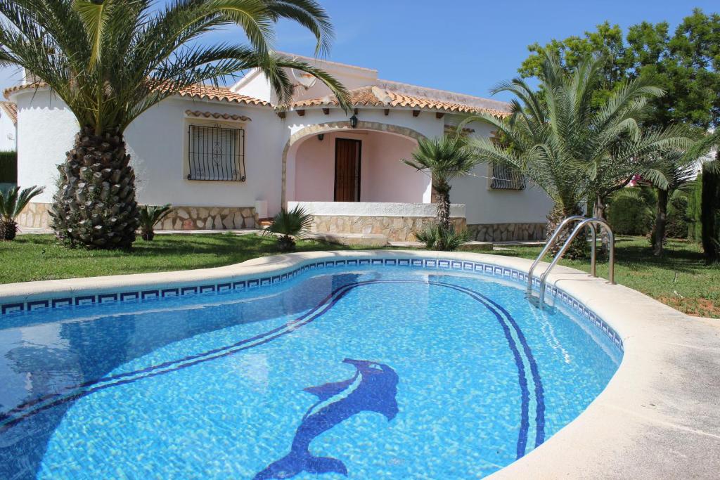 une piscine en face d'une maison avec un dauphin peint sur elle dans l'établissement Villas Los Olivares - Deniasol, à Els Poblets