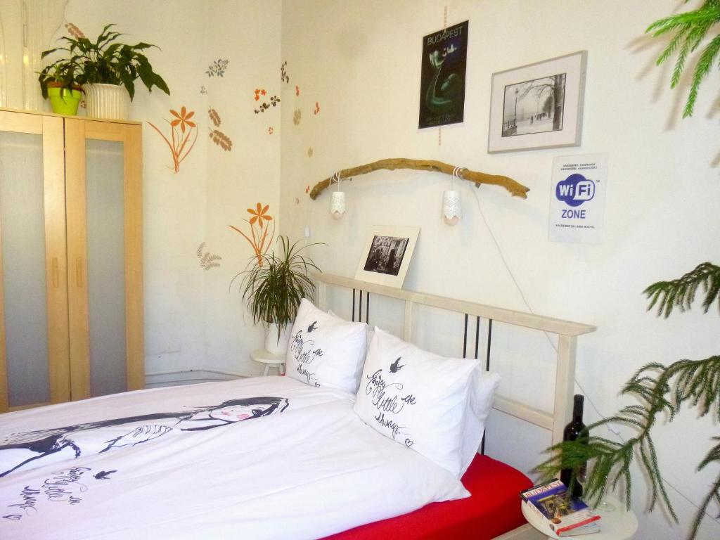 a bed in a room with plants on the wall at Gaia Hostel in Budapest