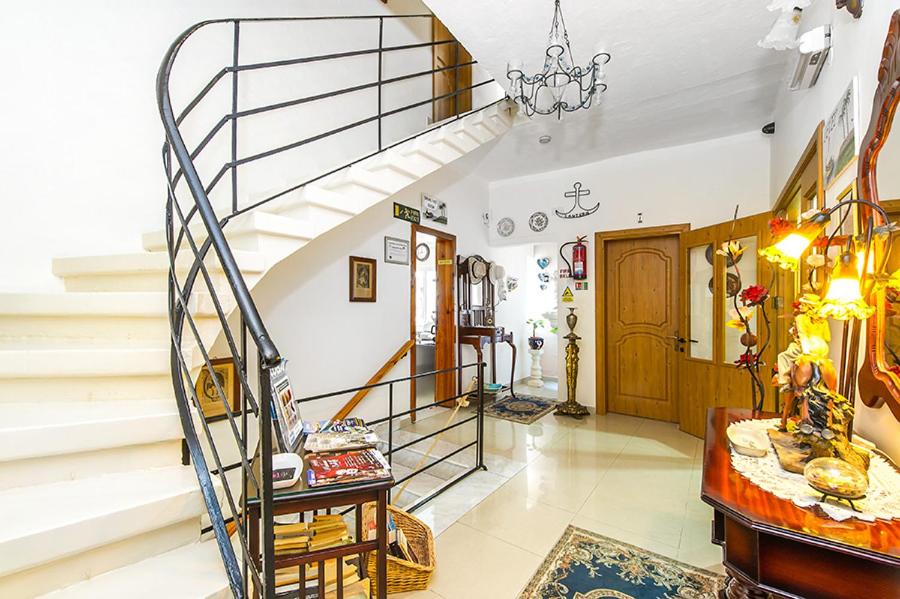 a living room with a spiral staircase in a house at Lantern Guest House in Marsalforn