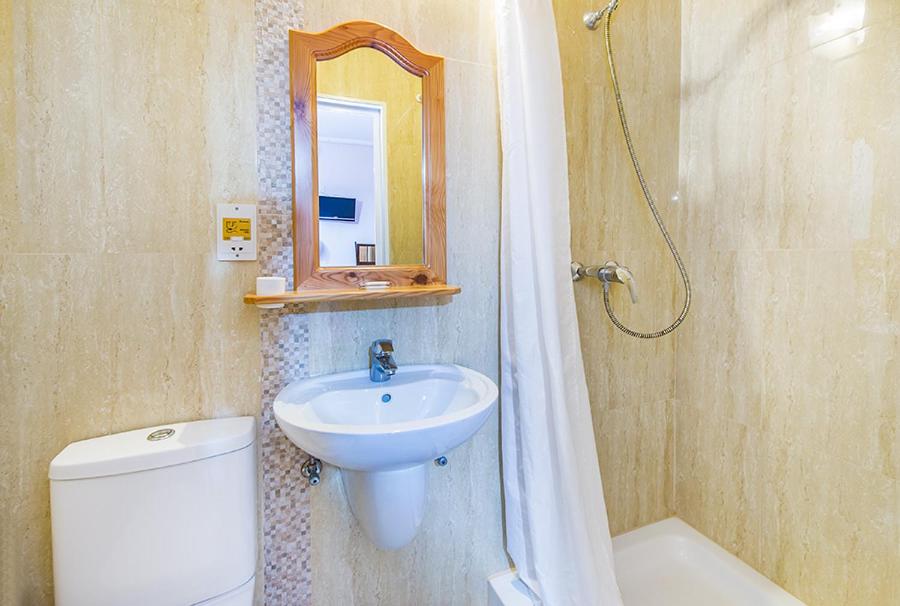 a bathroom with a sink and a toilet and a mirror at Lantern Guest House in Marsalforn