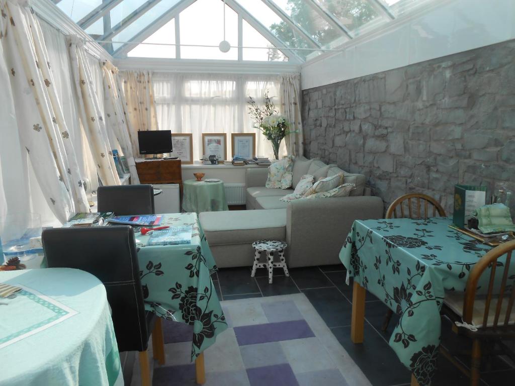uma sala de estar com um sofá e duas mesas em Lletygwilym, Heol dwr em Kidwelly