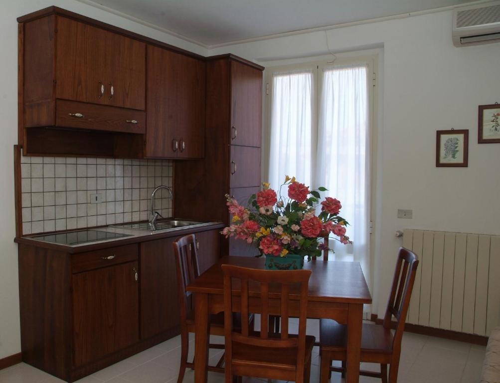 una cocina con una mesa con un jarrón de flores. en C.A.V. Residenza Prisco, en Marina di Grosseto