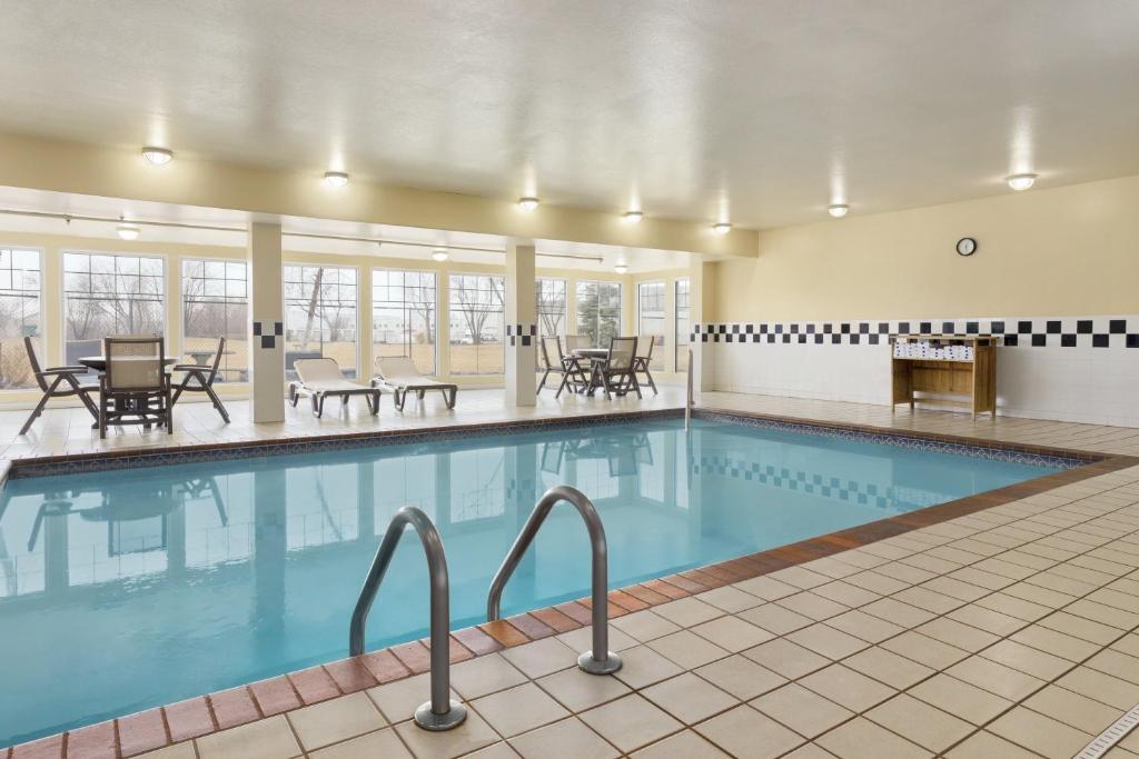 オマハにあるCountry Inn & Suites by Radisson, Omaha Airport, IAのテーブルと椅子付きのホテル内のプールを利用できます。