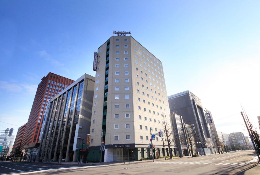 un edificio blanco alto en una calle de la ciudad en Richmond Hotel Sapporo Ekimae, en Sapporo