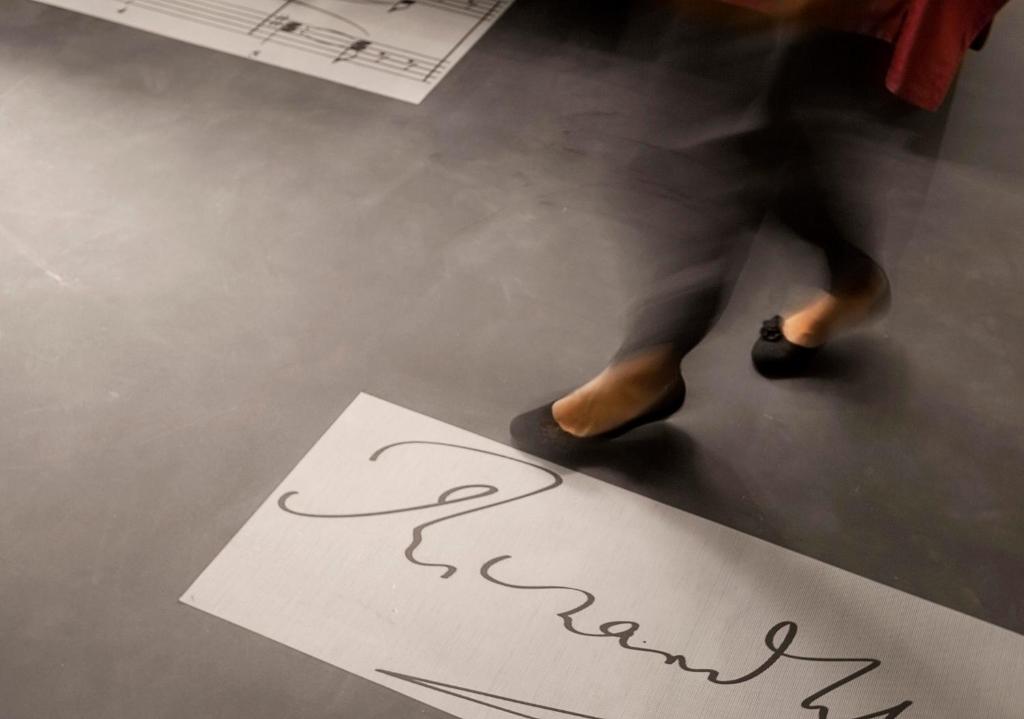 a person walking past a sign with the word karma at Hotel Sonne in Füssen