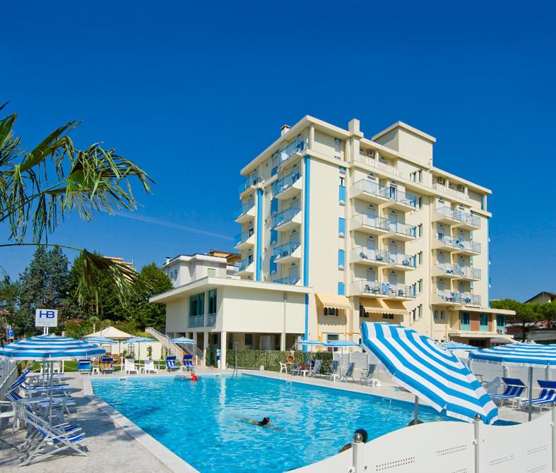 a hotel with a swimming pool in front of a building at Hotel Bolivar in Lido di Jesolo