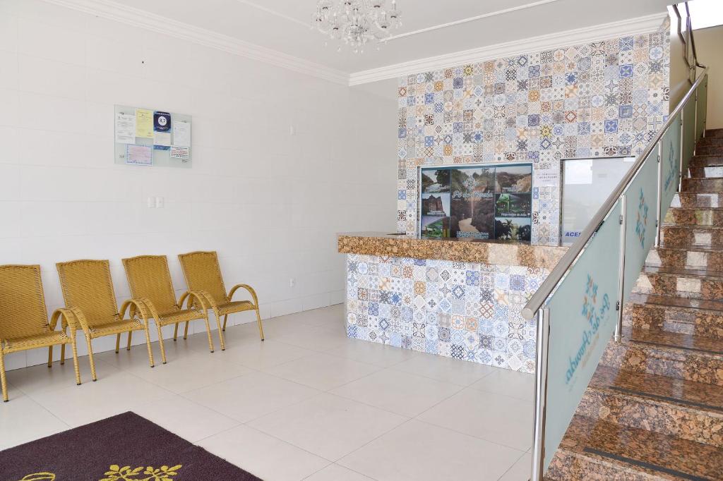 a waiting room with yellow chairs and a staircase at Pousada Pé De Arruda in Tucano