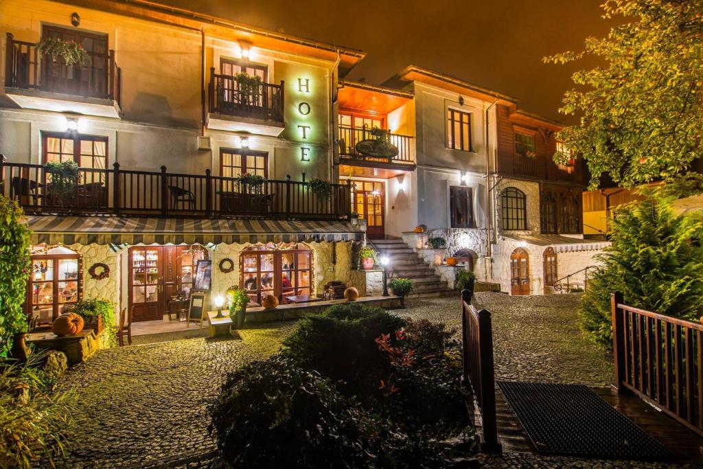 an old house with a staircase in front of it at night at Hotel Dwa Księżyce in Kazimierz Dolny