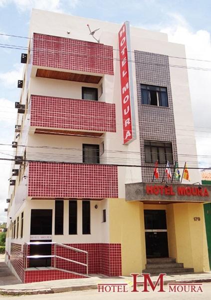 un edificio de hotel con un letrero rojo. en Hotel Moura, en Brumado