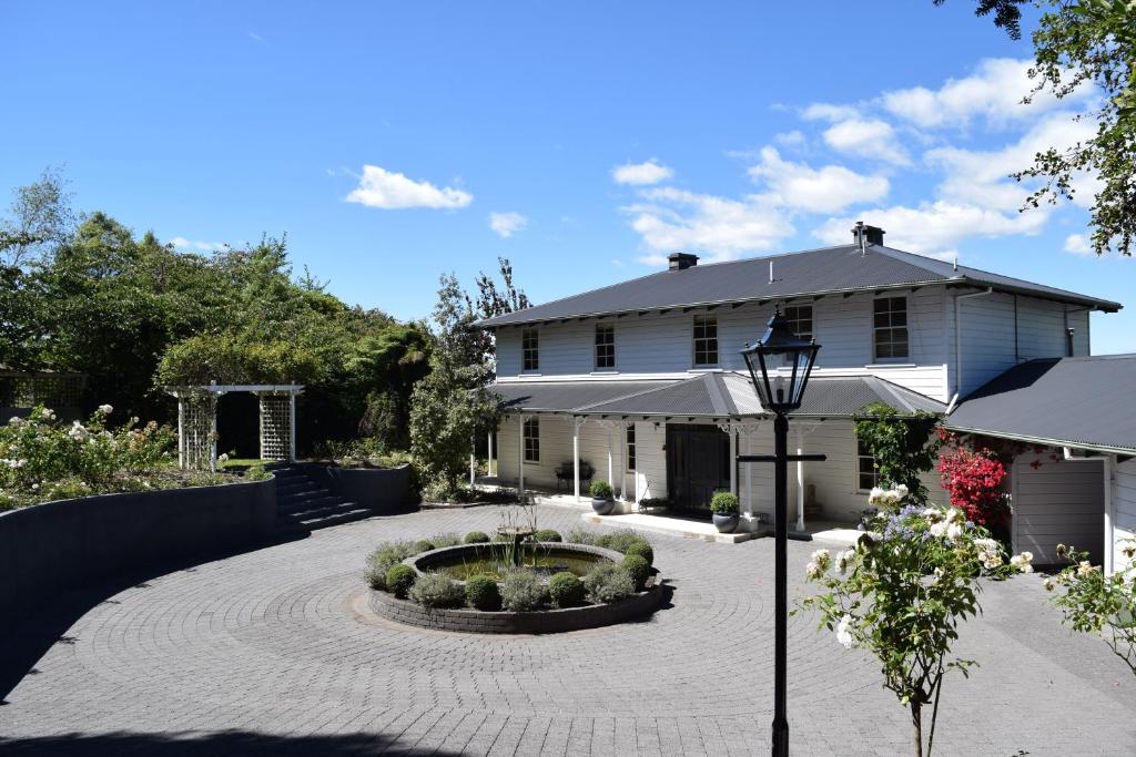 a house with a courtyard with a fountain in front of it at Bellevue Boutique Lodge in Taupo