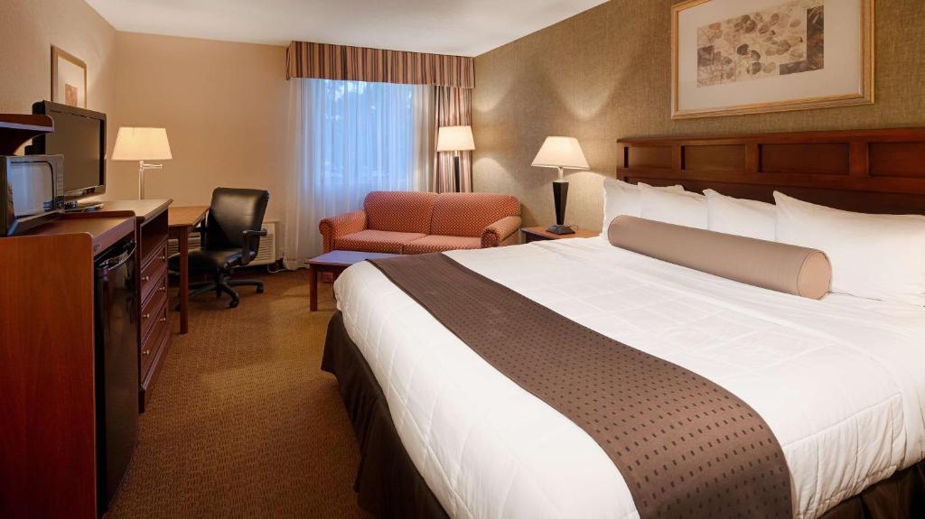 a hotel room with a large bed and a desk at Baymont Inn & Suites in Marietta