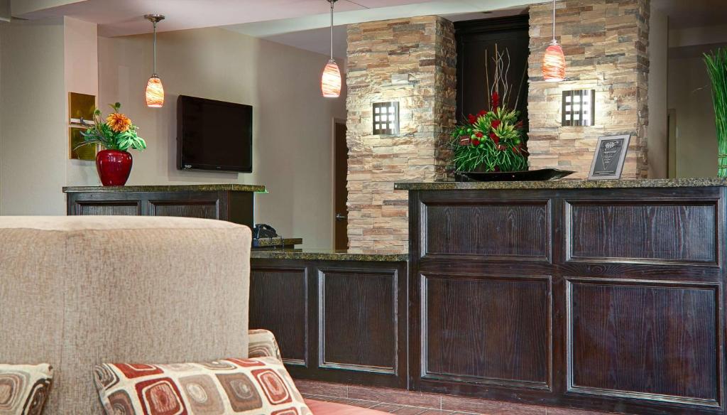 sala de estar con bar y TV en Best Western Plus Cushing Inn & Suites, en Cushing