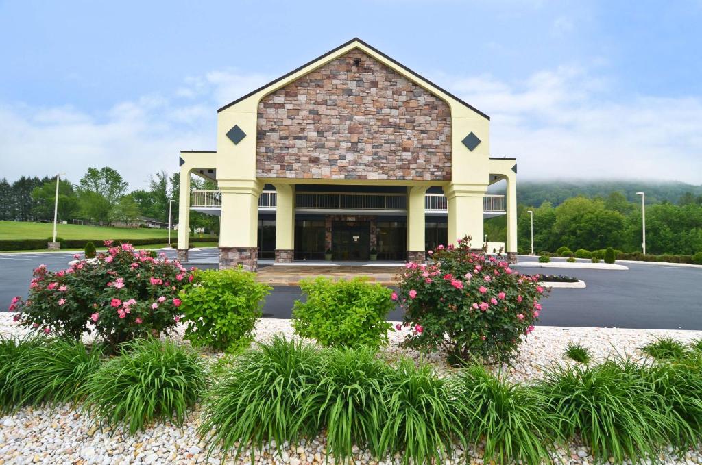 un edificio con flores delante de un aparcamiento en Best Western Cades Cove Inn, en Townsend