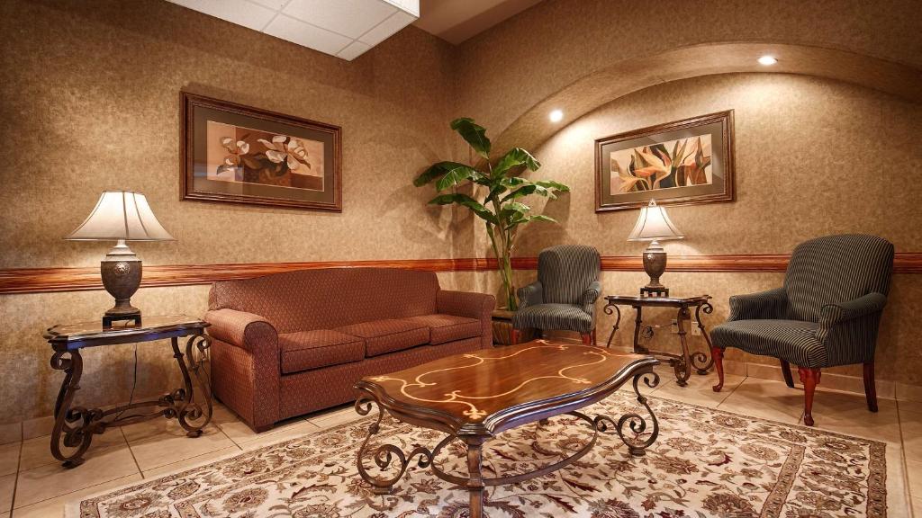 a living room with a couch and two chairs and a table at Best Western Casa Villa Suites in Harlingen