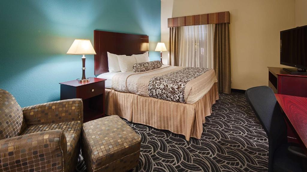 a hotel room with a bed and a couch at Best Western Plus Katy Inn & Suites in Katy