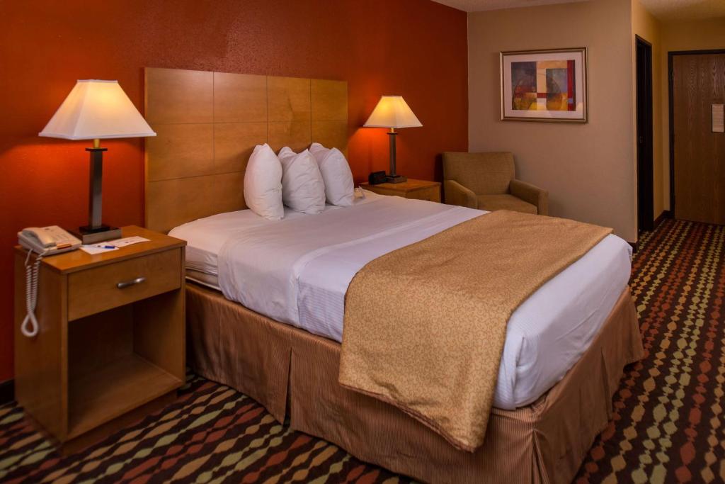 a hotel room with a large bed and a telephone at Best Western Ambassador Inn & Suites in Wisconsin Dells