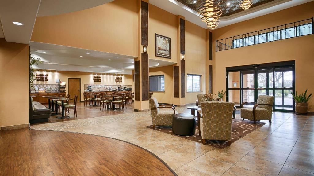 a lobby with tables and chairs and a restaurant at Best Western Plus Palo Alto Inn and Suites in San Antonio