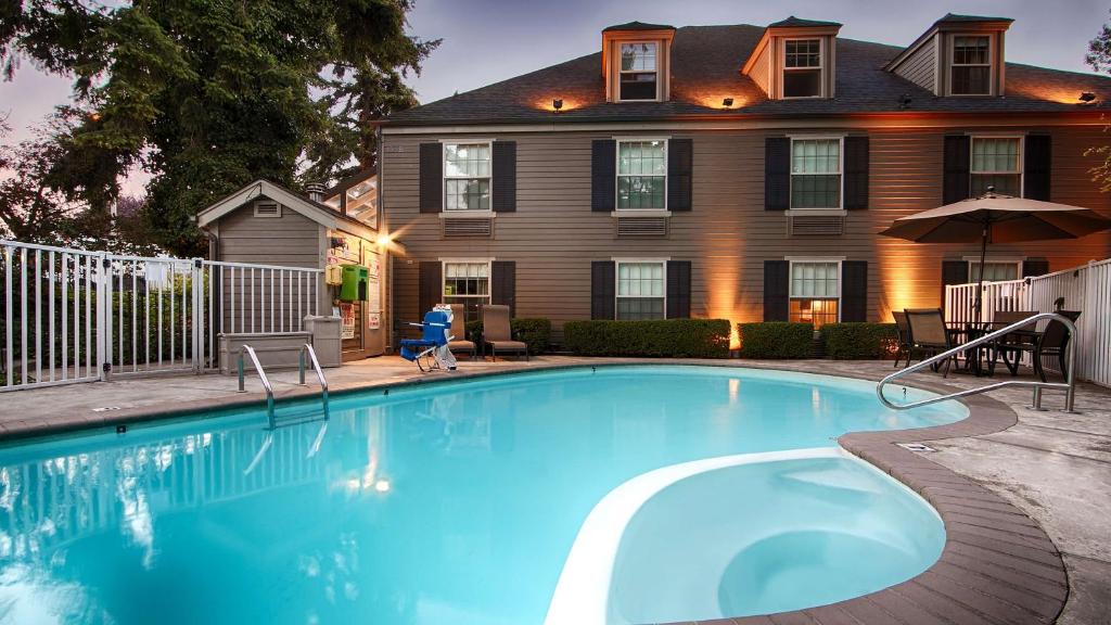 a swimming pool in front of a house at Wingate by Wyndham Bellingham Heritage Inn in Bellingham